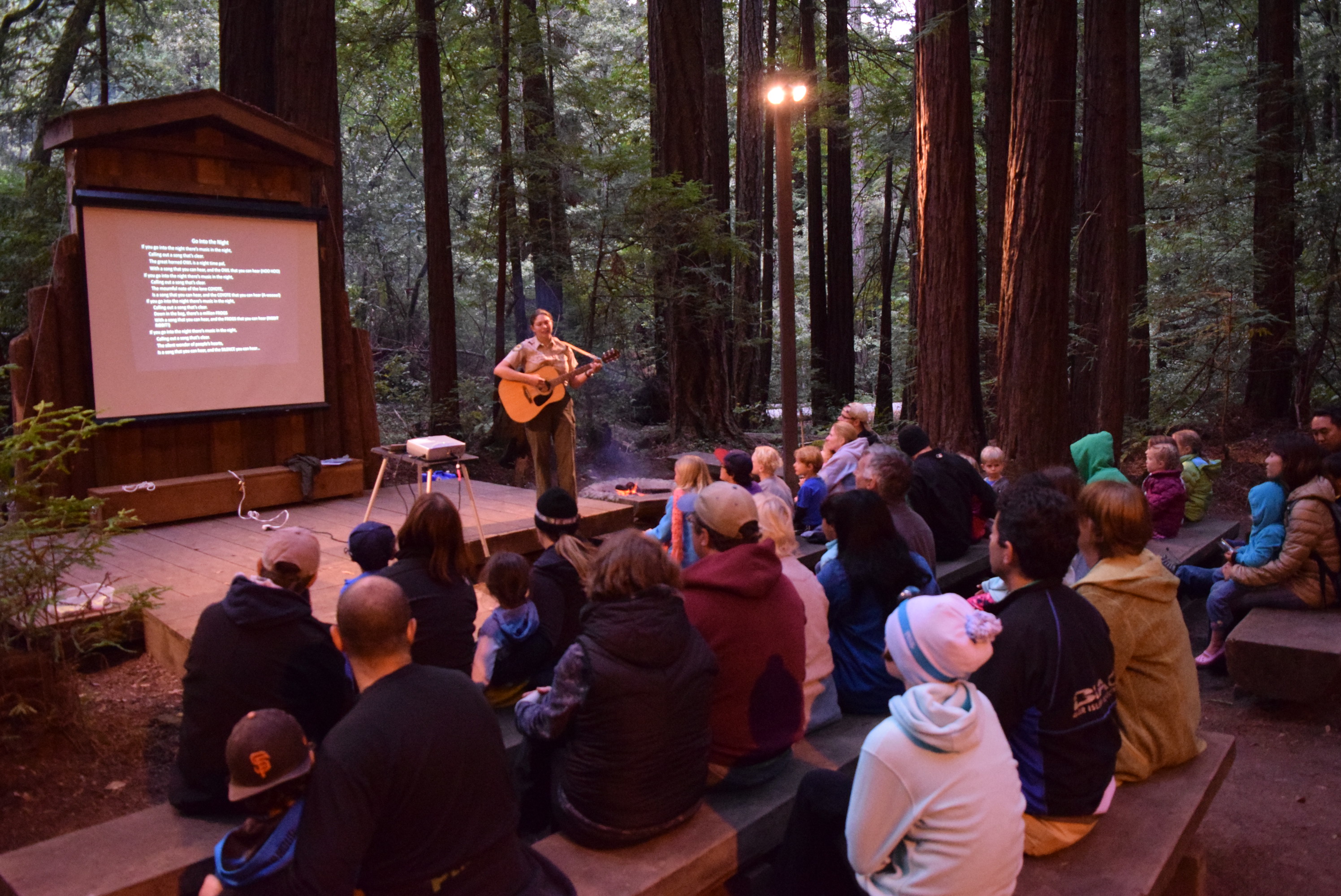 Interpretive staff leading the song portion of a summer campfire program at Butano State Park